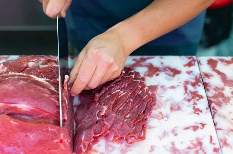 MANO CORTANDO TROZO DE CARNE